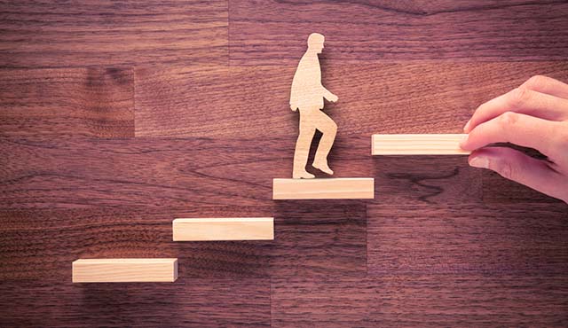 Cutout of a man walking up stairs against a wood background